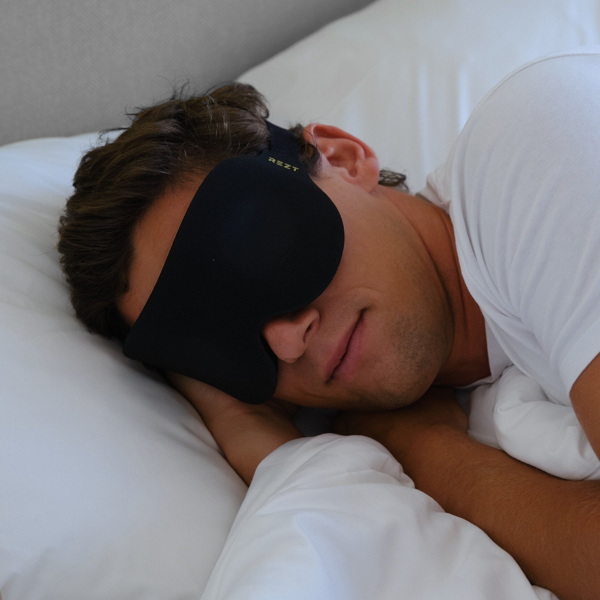 Mann sover komfortabelt med REZT sovemaske	