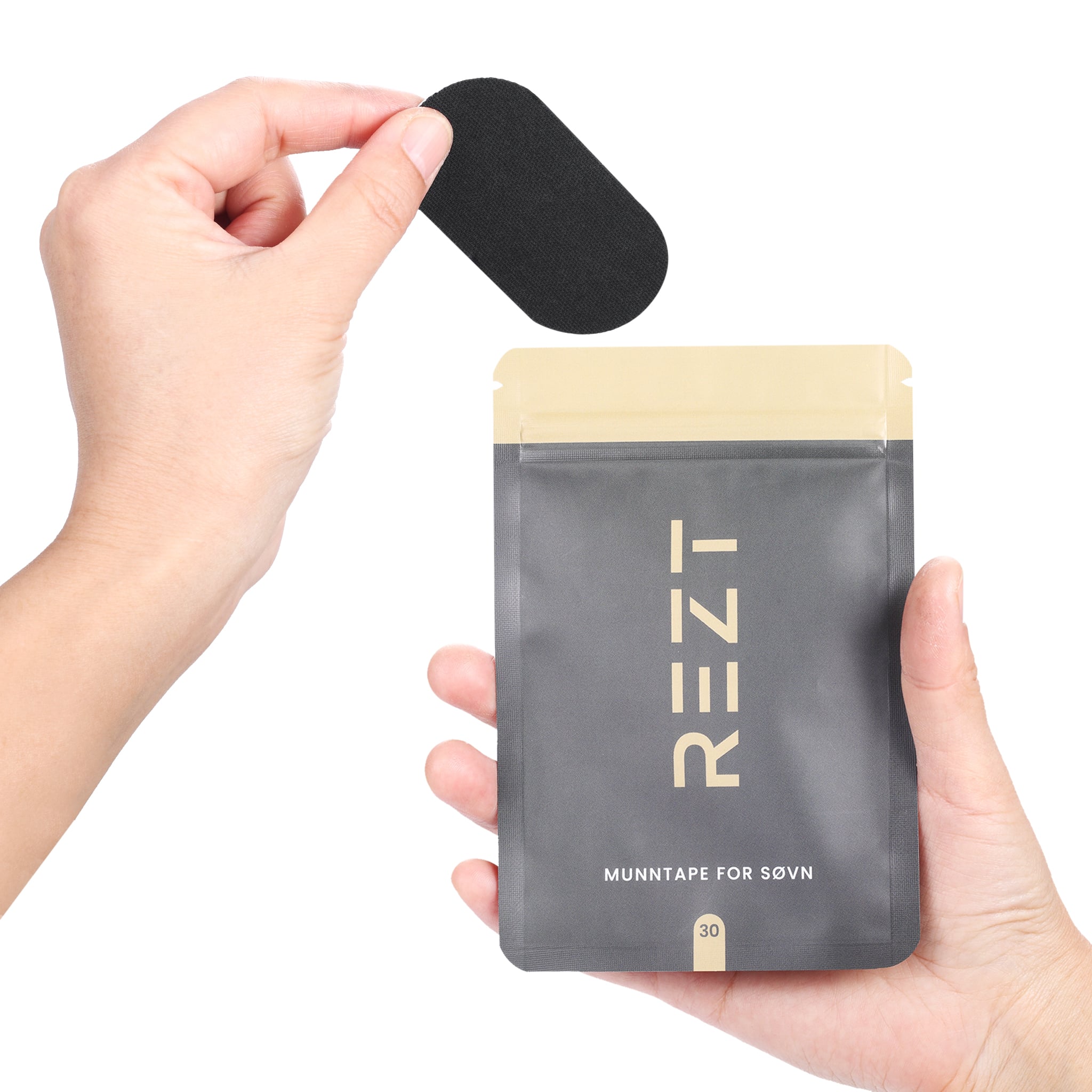 REZT munntape - Hånd som holder svart stripe med grå og gullfarget emballasje i bakgrunnen.
