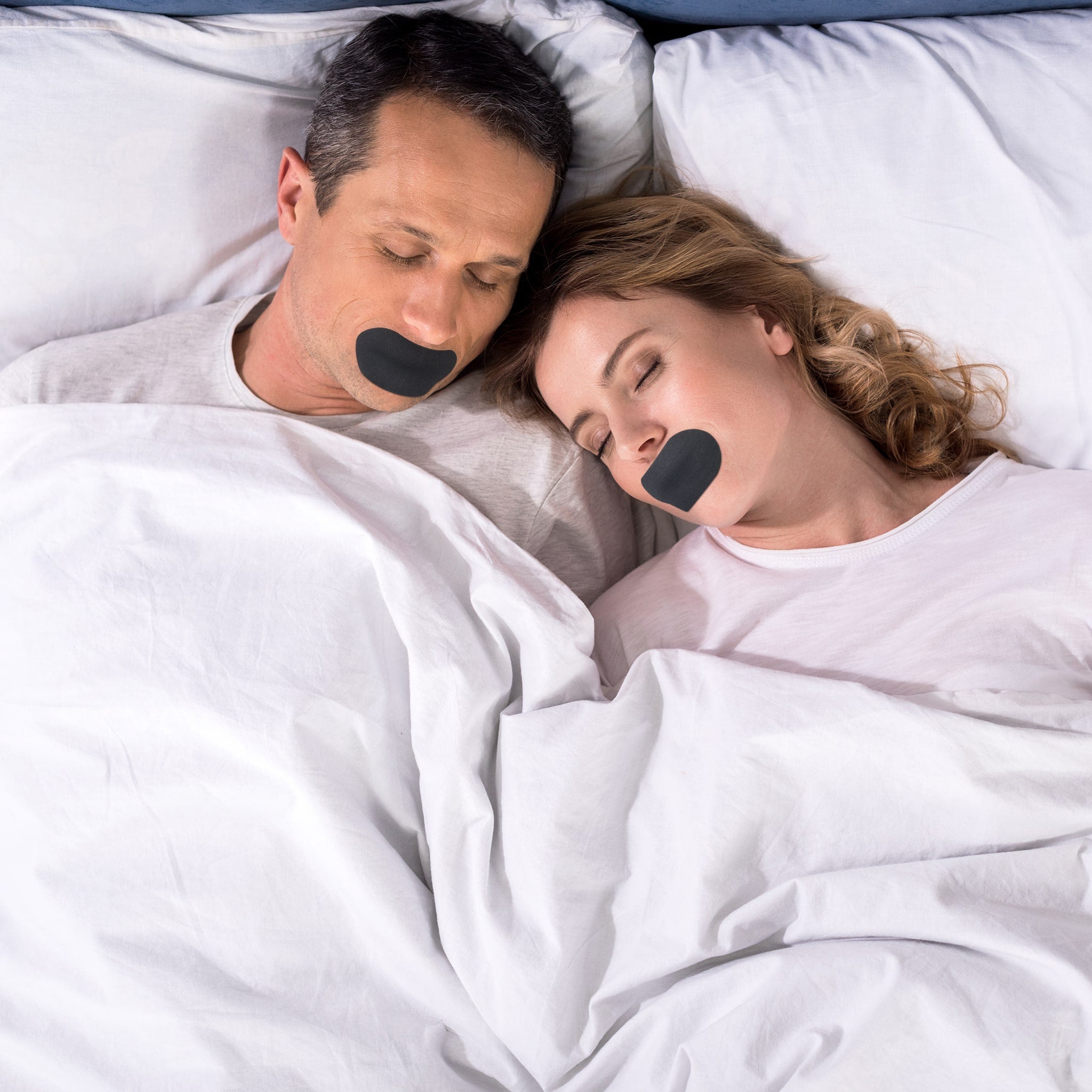 Par i sengen med svarte munntape-striper, sover fredelig.