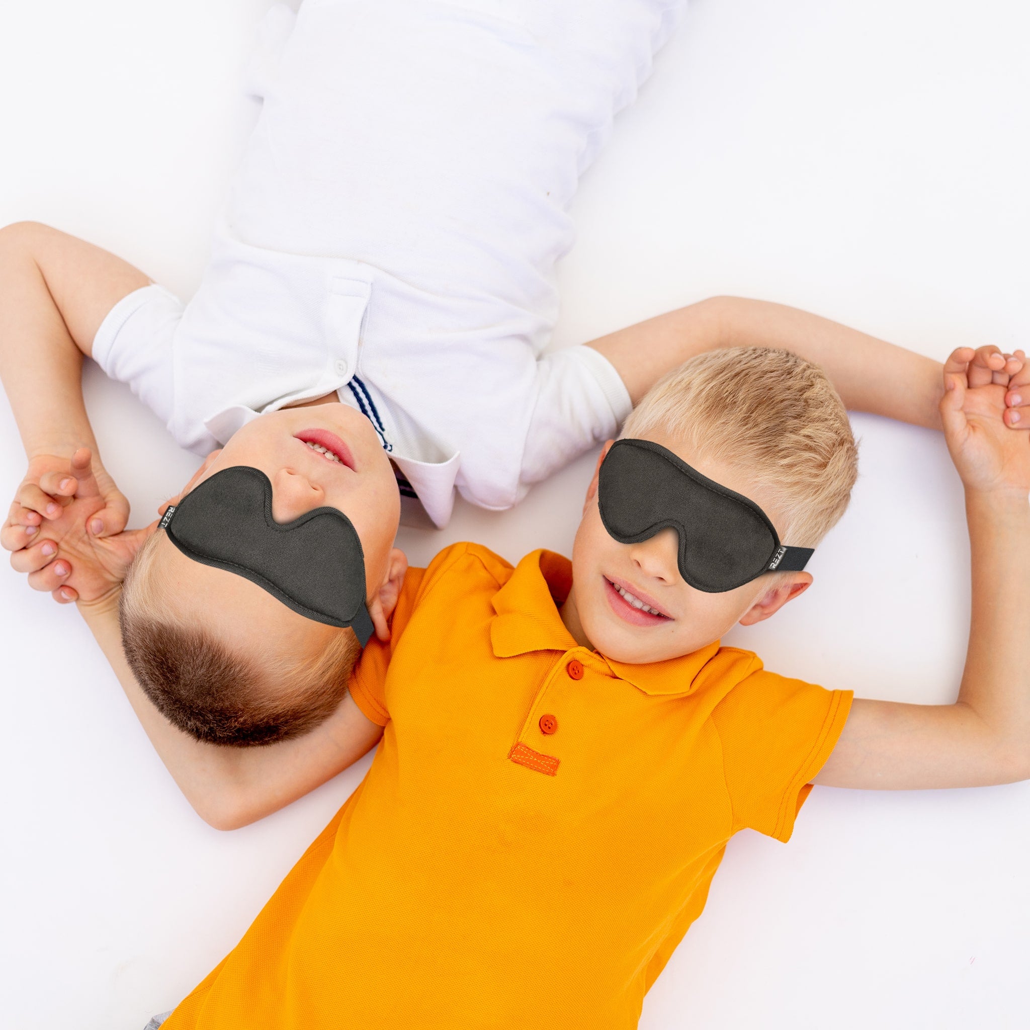 To barn som har på seg REZT Sovemaske For Barn 